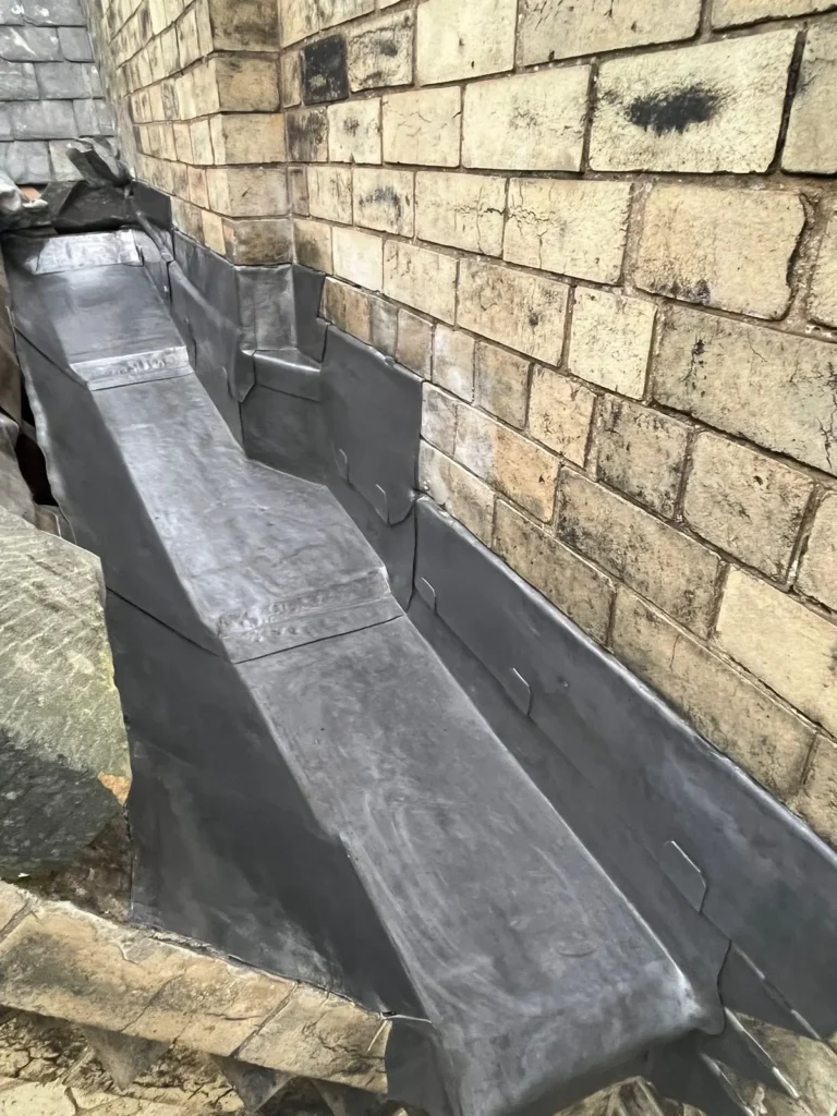 Lead box gutter against stonework